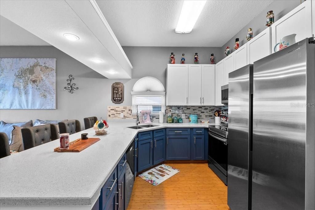 This fresh updated kitchen will please your inner master chef. There's plenty of storage with tall uppers and beautiful lower cabinets, quartz counters, great appliances and another lovely bright arched window.