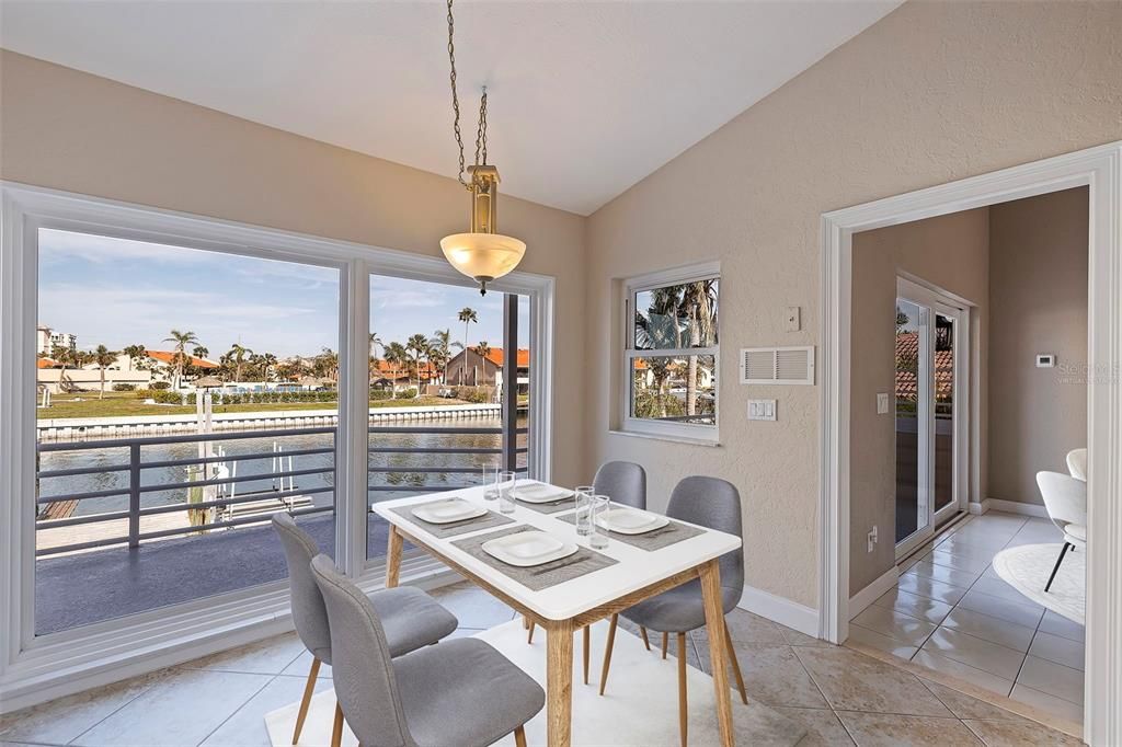 View to outdoor balcony from kitchen with eat-in space area. This photo has been virtually staged.