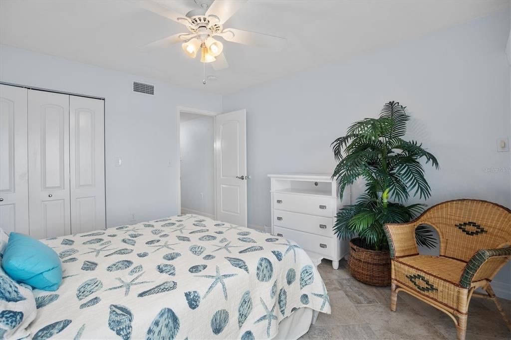 Guest bedroom with queen bed, views of Tampa Bay, and patio access.