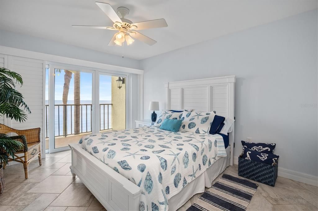 Guest bedroom with queen bed, views of Tampa Bay, and patio access.