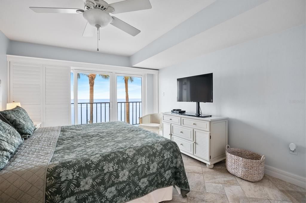 Primary bedroom with king size bed, views of Tampa Bay, and patio access.