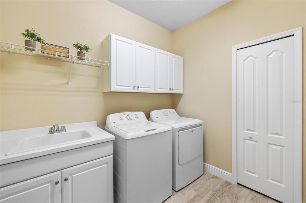 Laundry/Utility room with sink, cabinets and closet