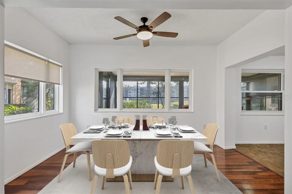 Dining room off living room with view of lanai and pond. Virtually staged