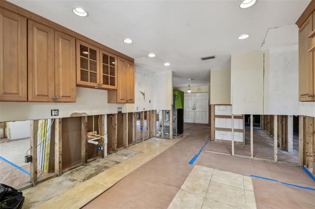 Kitchen looking toward the front door.  Primary ensuite to the right as well as laundry room and garage entrance.