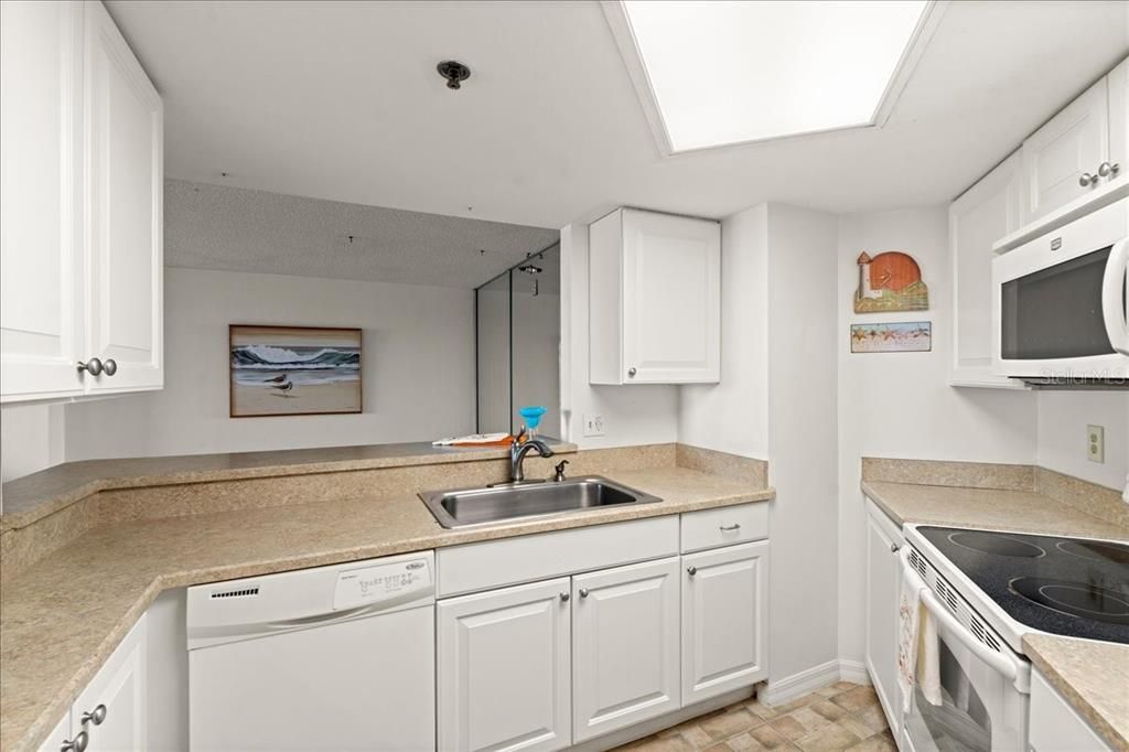 Kitchen with light appliances and cabinetry