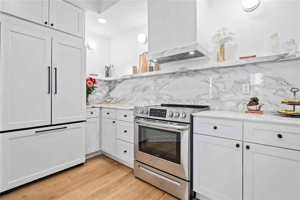 Panel-covered appliances and marble trimmed exhaust hood