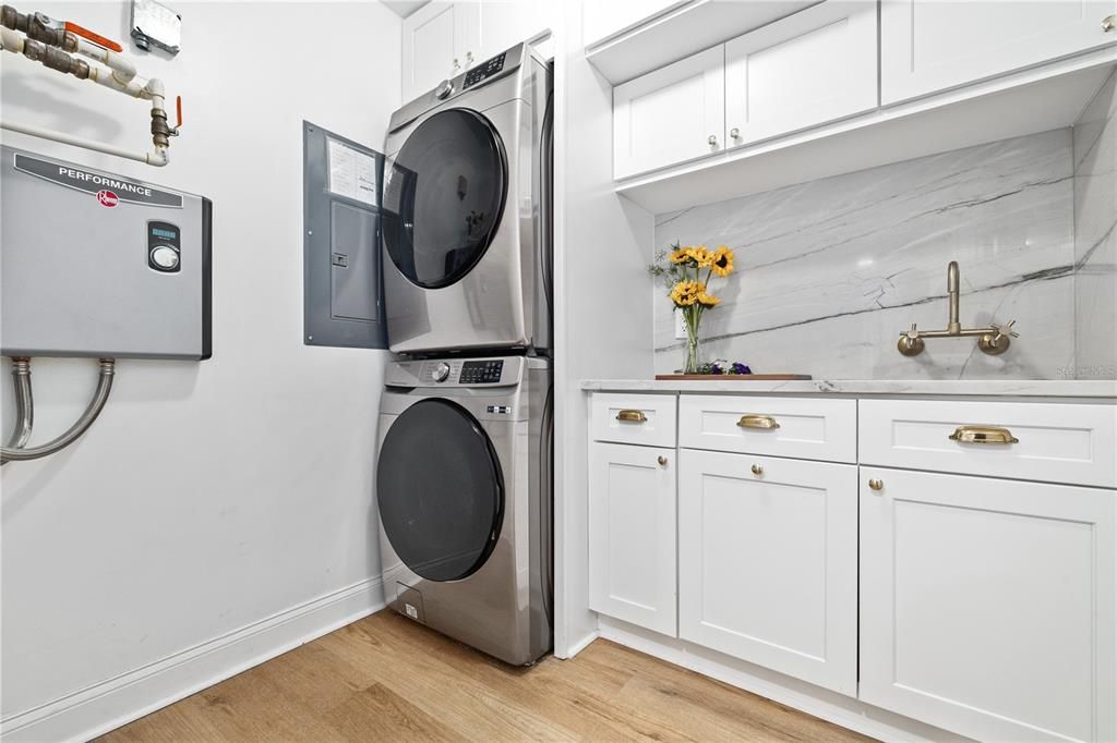 Major laundry room UPGRADE! Tankless hot water heater, stackable smart appliances and abundant storage with luxury finishes