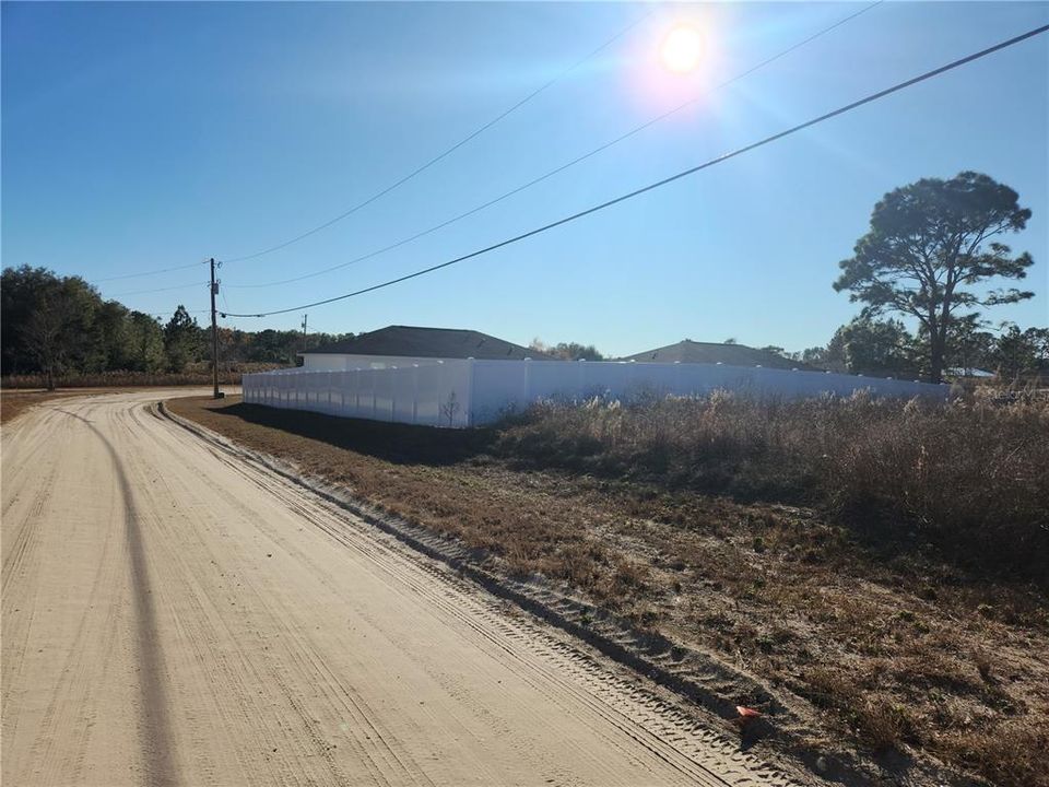 fence on street to the west behind the lot with several new house  ( 146th Ct )