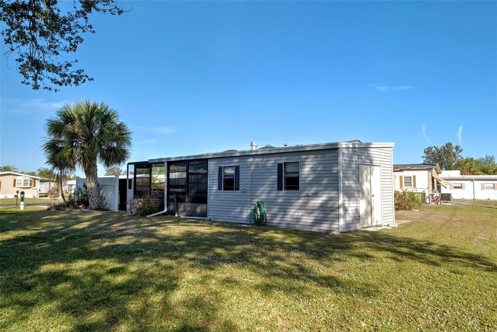 SIDE VIEW - ATTACHED LAUNDRY ROOM AND LARGE SHED WITH EXTERIOR ACCESS DOOR.