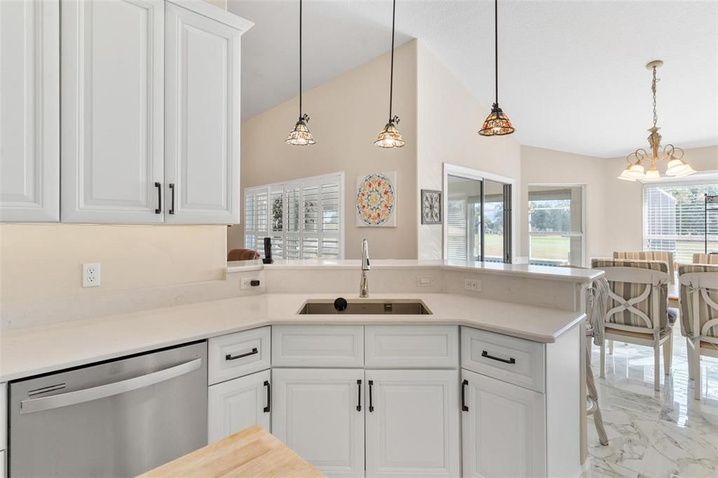 Remodeled kitchen features new cabinets, quartz countertops, soft close drawers, and porcelain tile.