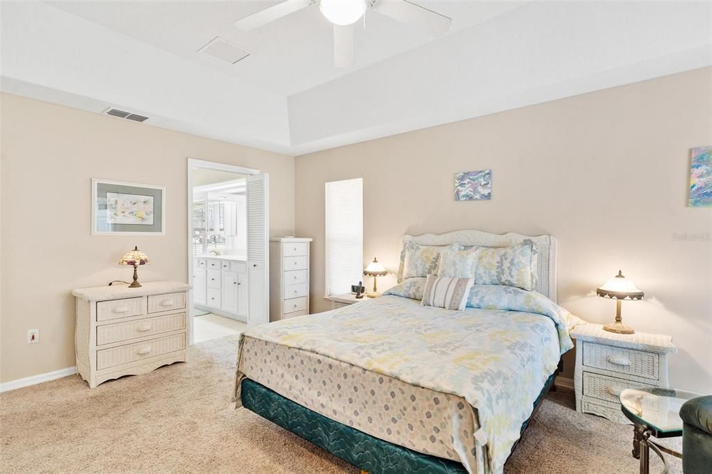 Primary bedroom features trey ceilings and sliders leading to Florida Room.