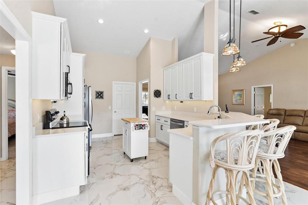 Remodeled kitchen features new cabinets, quartz countertops, soft close drawers, and porcelain tile.