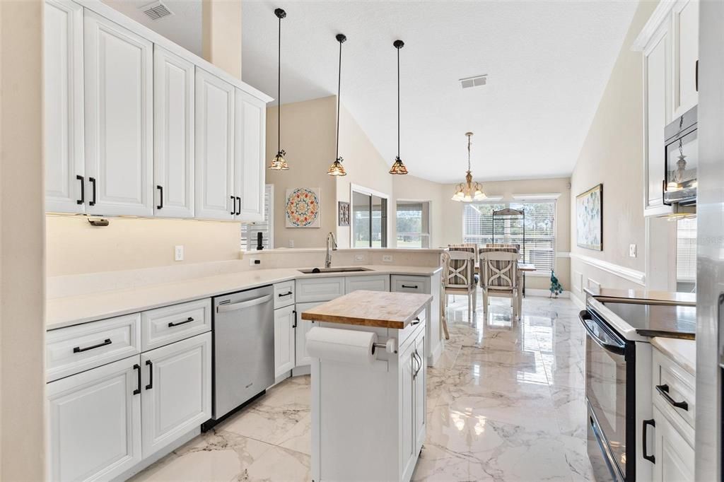 Remodeled kitchen features new cabinets, quartz countertops, soft close drawers, and porcelain tile.