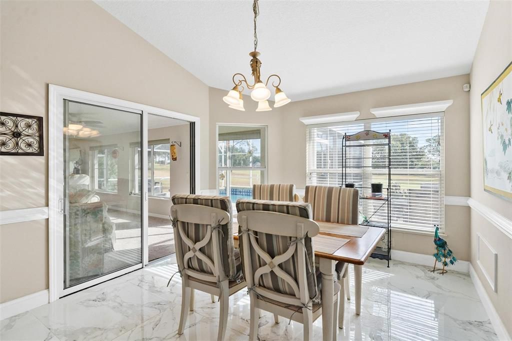 Kitchen nook overlooks kitchen, florida room, and swimming pool with views of golf course.