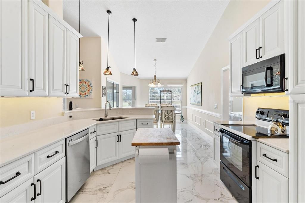 Remodeled kitchen features new cabinets, quartz countertops, soft close drawers, and porcelain tile.