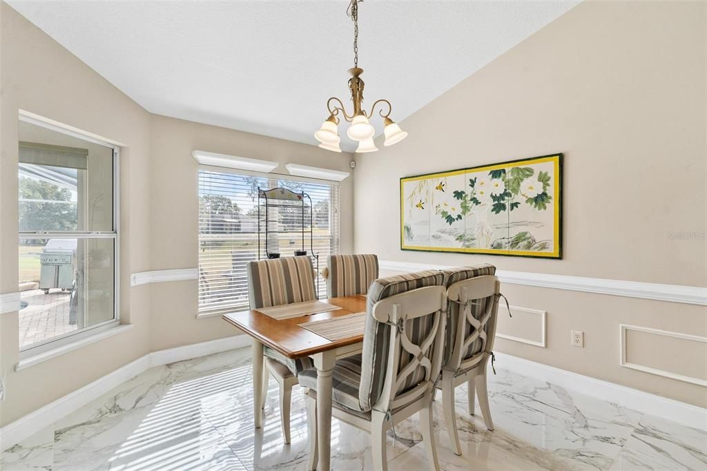 Kitchen nook overlooks kitchen, florida room, and swimming pool with views of golf course