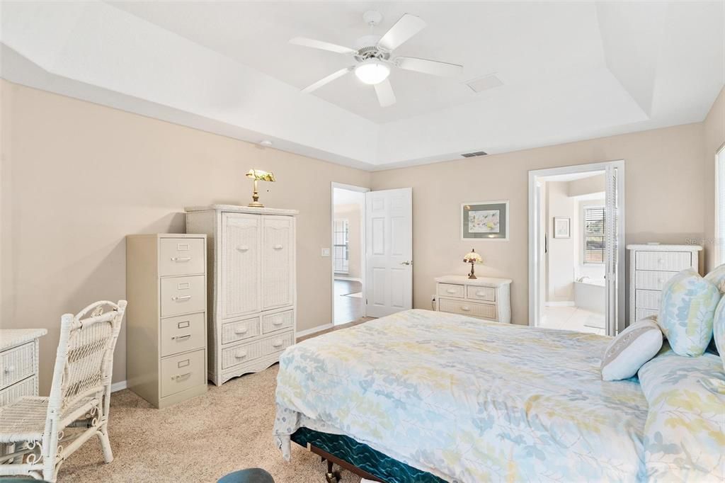 Primary bedroom features trey ceilings and sliders leading to Florida Room.