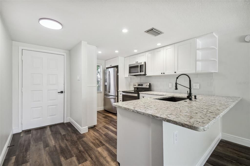 NEW LUXURY VINYL PLANK FLOORING THROUGHOUT, NEW KITCHEN WITH MODERN CABINETRY+HARDWARE, QUARTZ COUNTERTOPS, SS APPLIANCES, ADDITIONAL DRY GOODS PANTRY, LED LIGHTING, NEW HVAC, FRESHLY PAINTED INTERIOR.