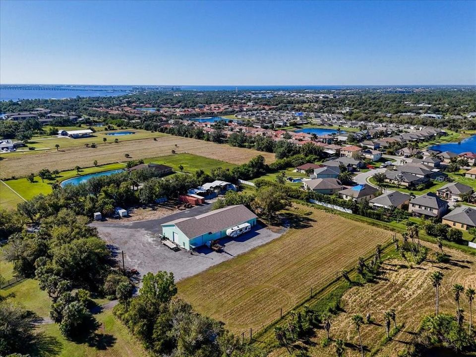 Aerial View of Commercial Building with Offices, Hobby Shop, Workshop/Garage and outbuildings with parking ports. Potential for Stables!