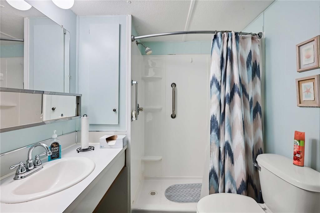 Nicely updated bathroom including a step-in shower, high toilet, and vanity.