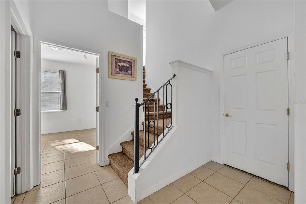 In front of third downstairs bathroom - the door on the right is the door for the garage and the stairs lead you to the upstairs bedroom/bathroom