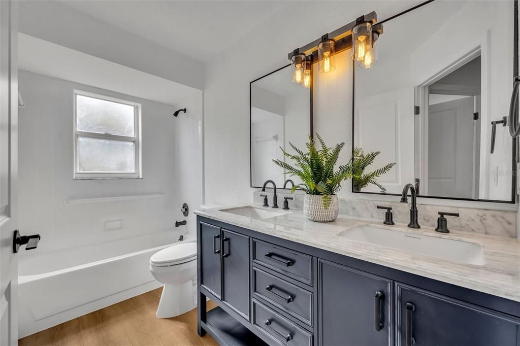 This is the primary bathroom which has dual sinks, marble countertop, dual mirrors and grab bars I'm the shower.