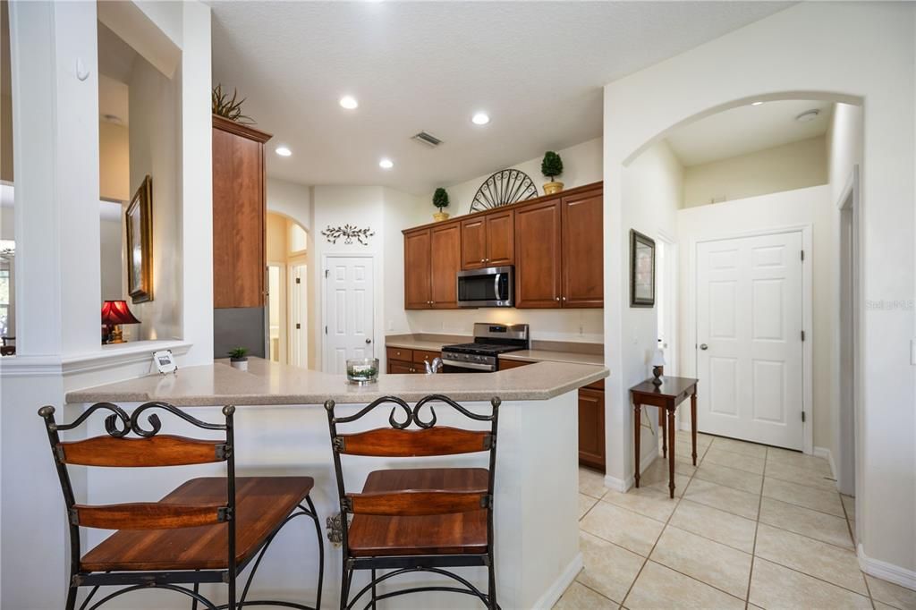 Past the living room is the open kitchen equipped with a breakfast bar