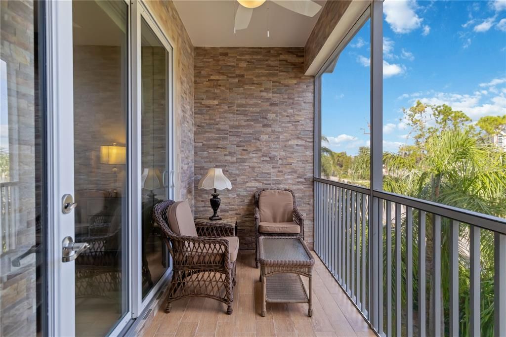 New tile planked and screened in private balcony with overhead ceiling fans