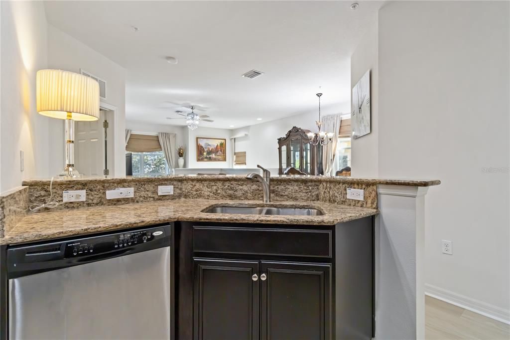 Kitchen is equipped with a breakfast bar overlooking living area.