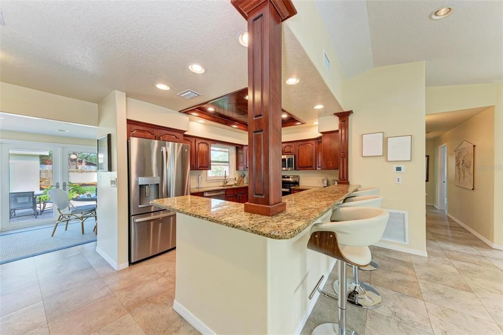 Beautiful Chefs kitchen with lots of storage coffered ceiling, brand new stainless appliances and granite countertops .