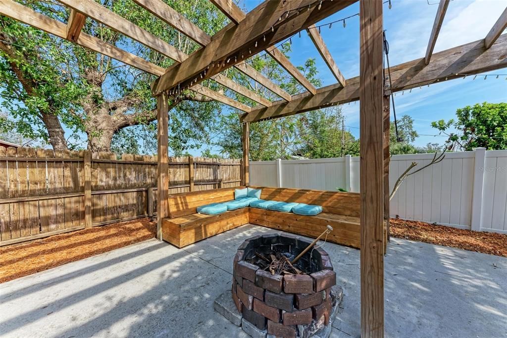 Fire pit under the pergola with built in benches.