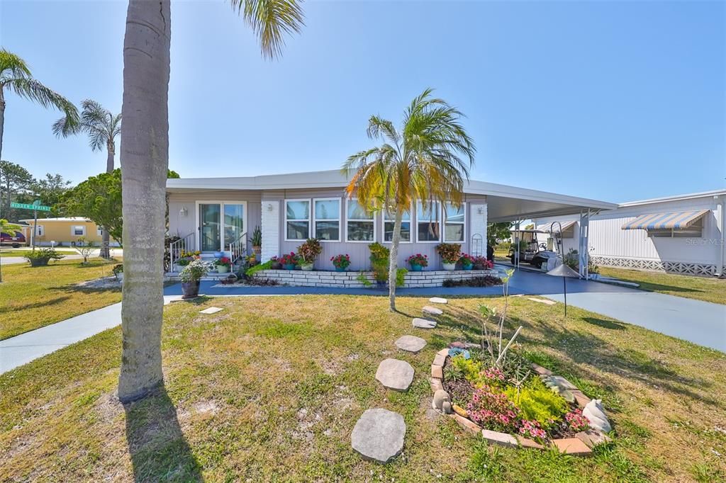 Nice large yard with flowers and palm trees