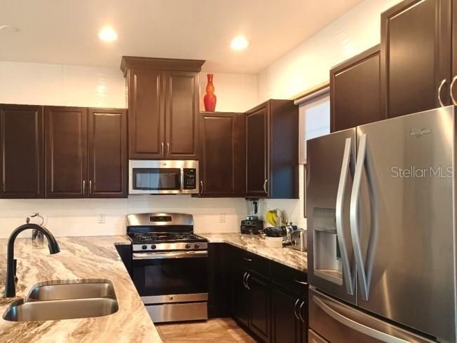 Dark wood kitchen cabinets and gas range