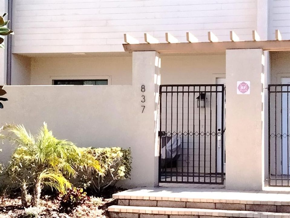 Walled gated patio in front of house entrance