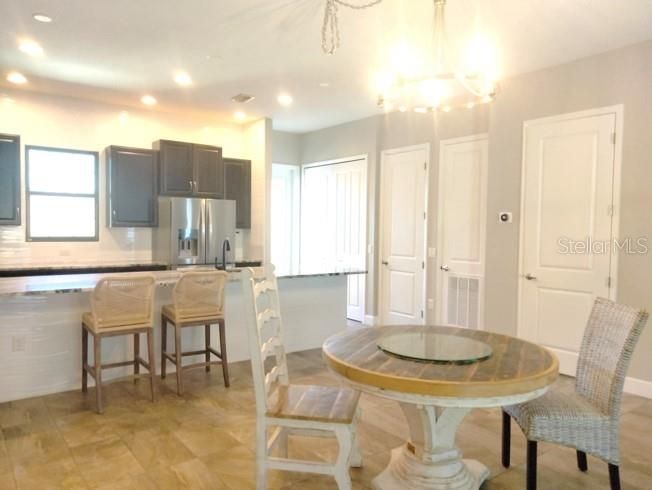 Contemporary brushed nickel light fixture over dining table