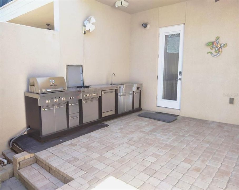 Extensive outdoor kitchen with rotisserie/grill burner, fridge ice store and sink