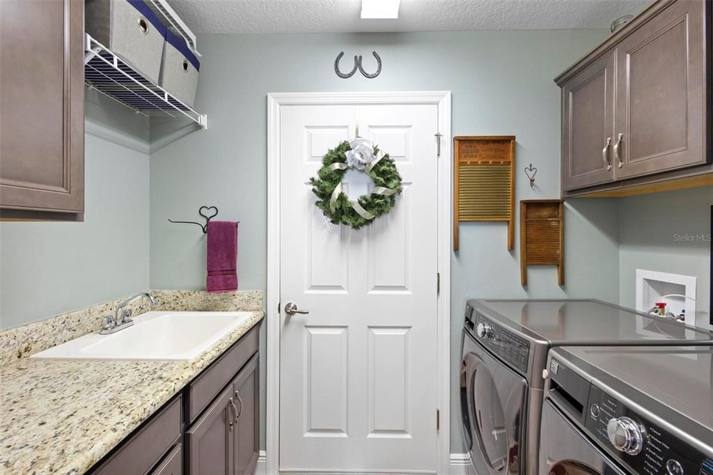 Interior laundry room with cabinets and wash sink