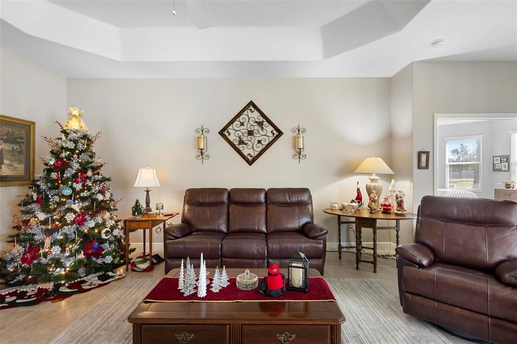 Great room with tray ceiling; primary bedroom to the right