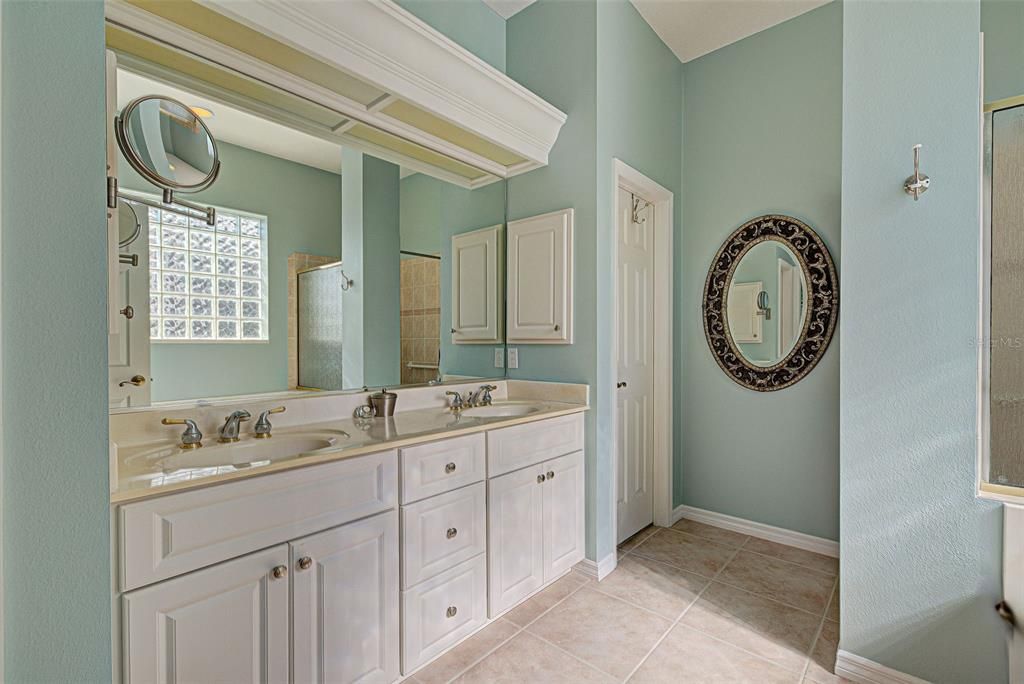 Ensuite bathroom has dual sinks and 2 walk-in closets with custom shelving.