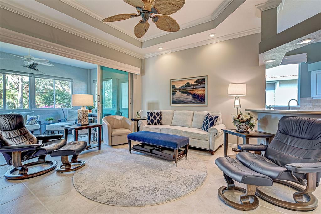 The great room features a tray ceiling, classy crown molding and over-sized ceramic tiles.