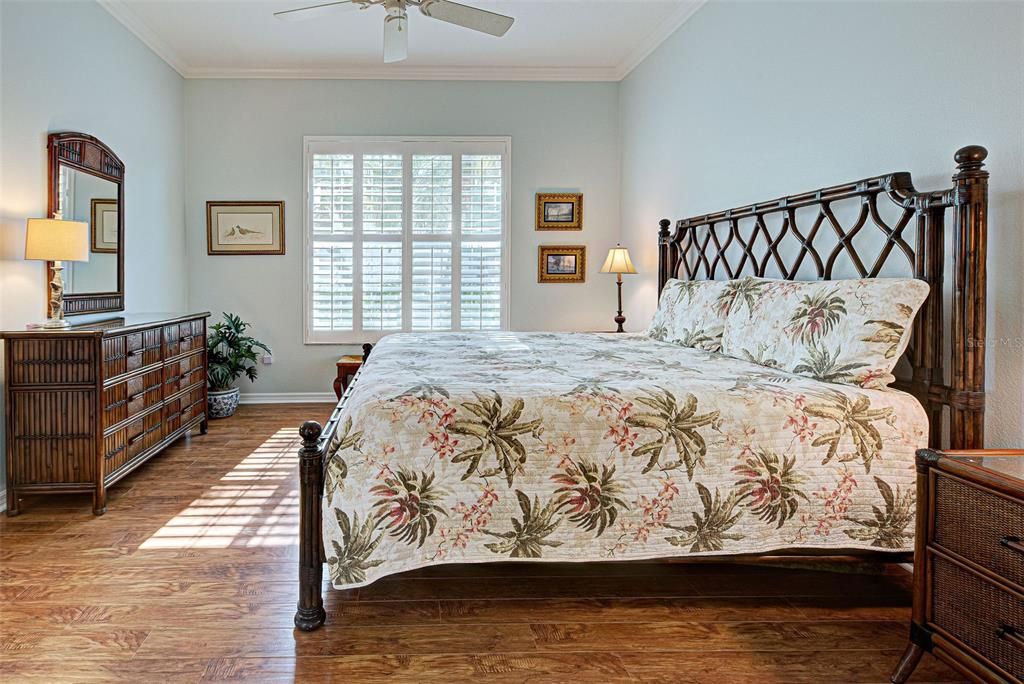 Guests will appreciate sunny 2nd bedroom with plantation shutters, crown molding and luxury plank flooring.