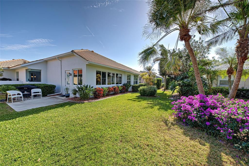 Lovely view of mature, exotic landscaping and large green space area behind the home.