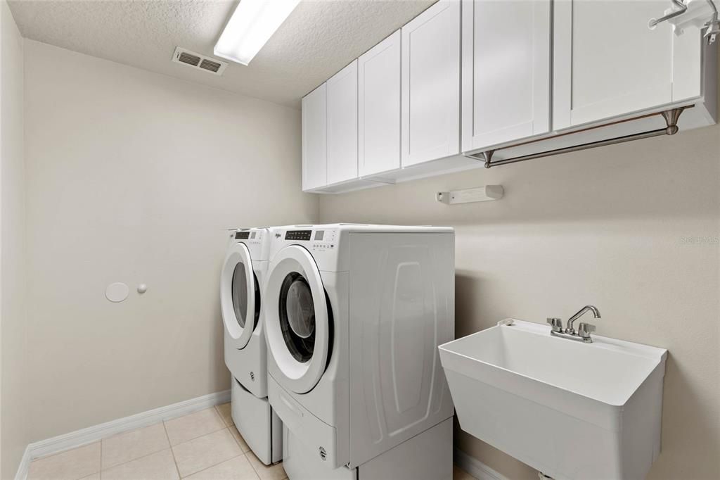 Laundry room with basin and cabinets