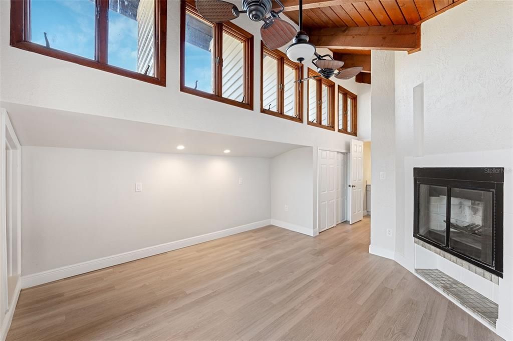 Upstairs master bedroom with a fireplace, very high vaulted ceilings and transient windows for lots of natural light.