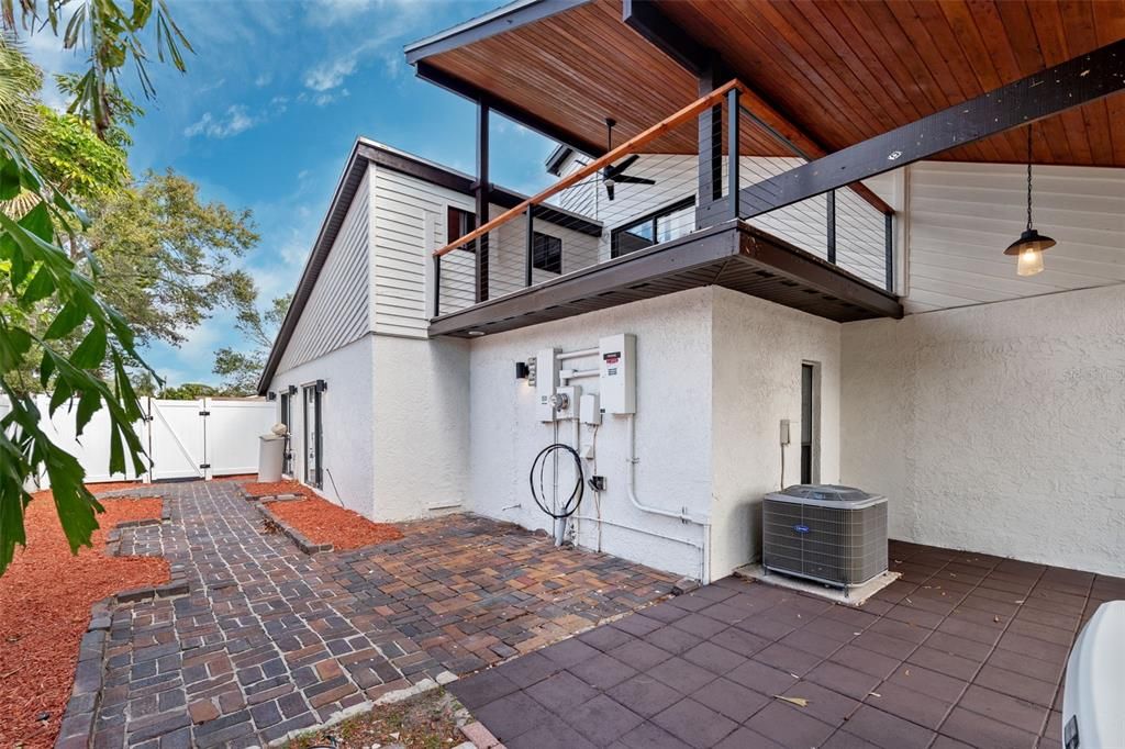 Sideyard leading from front driveway. Master bedroom slider entrance and second story master bedroom balcony