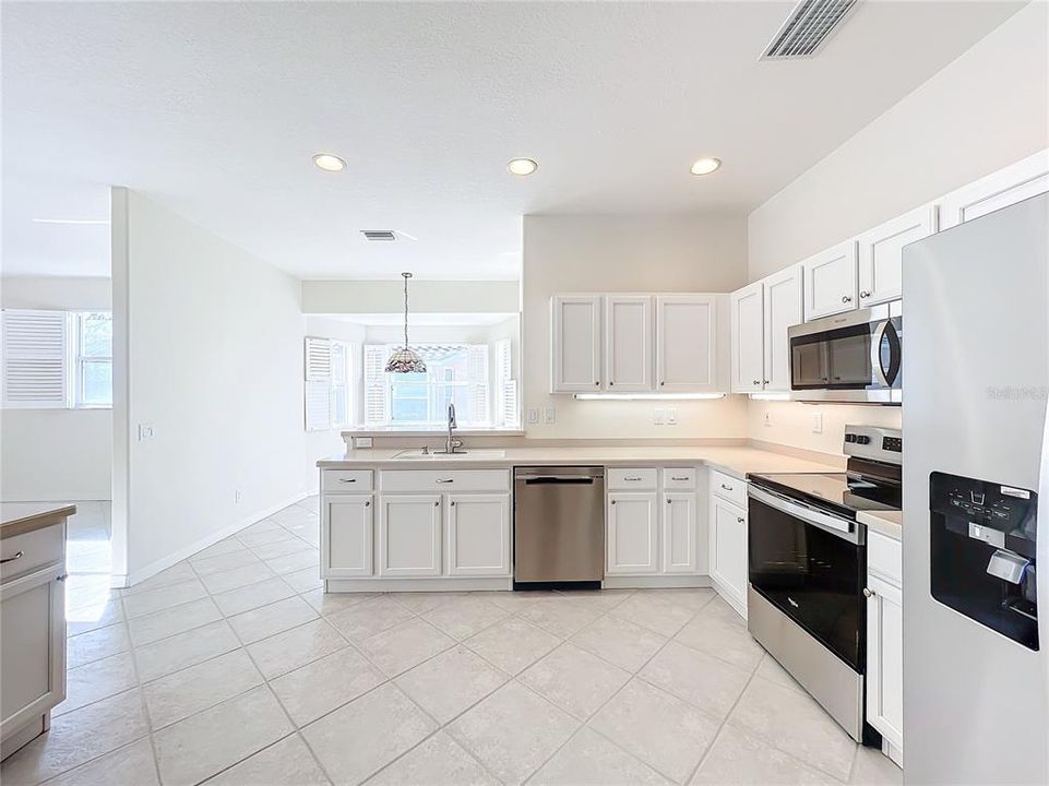 Breakfast bar, under cabinet lighting over Corian countertops.