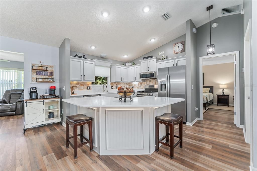 KITCHEN - What an exquisite place for culinary experiences! Note FAMILY ROOM (back L) and entrance to PRIMARY BR (on R).