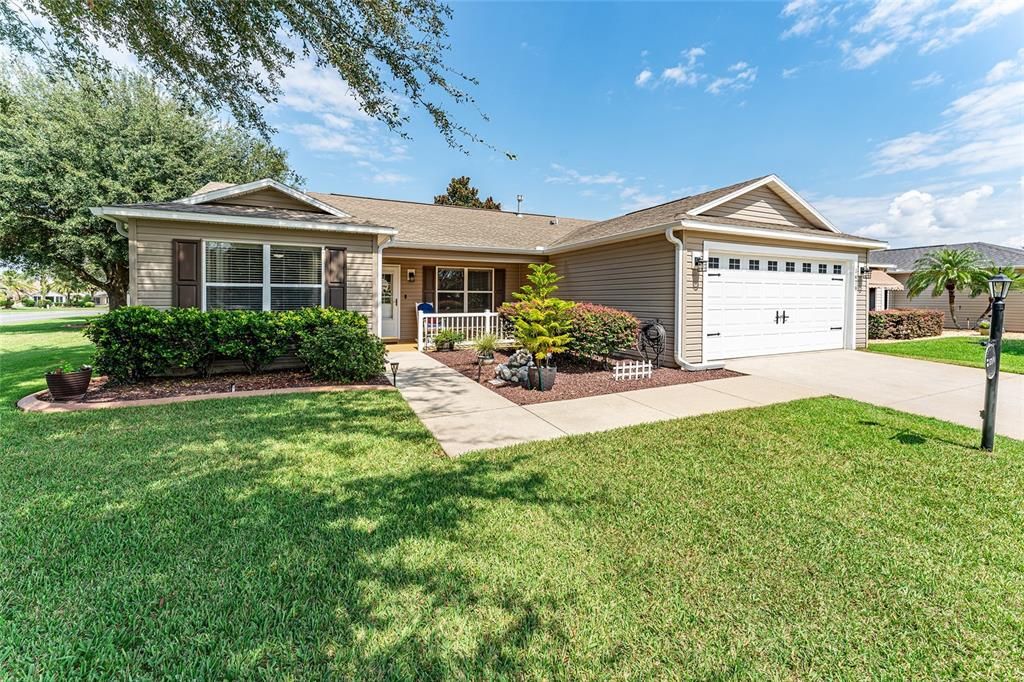 FRONT EXTERIOR - Note: NEW Architectural Shingle Roof installed 11/2024! This well loved home shows pride of ownership with meticulously cared for landscaping with CONCRETE CURBING, ROCK FILLED beds, and mature shrubs/trees.