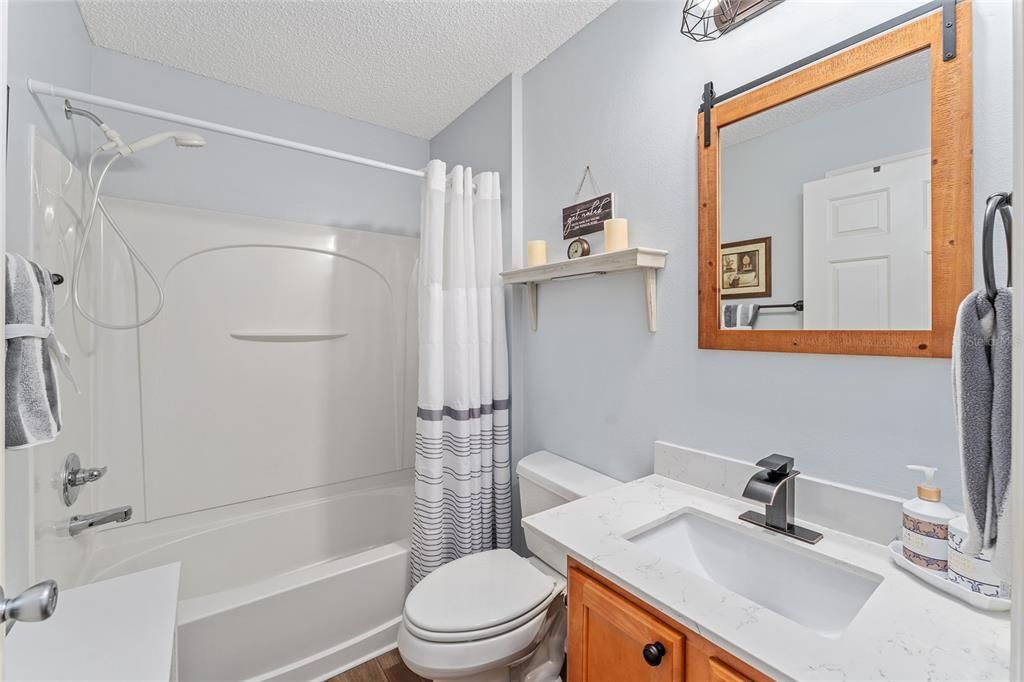 BATHROOM #2 boasts matching QUARTZ COUNTERTOP on a single vanity, new brushed nickel faucet, COMFORT HEIGHT TOILET, and TUB/SHOWER COMBO.