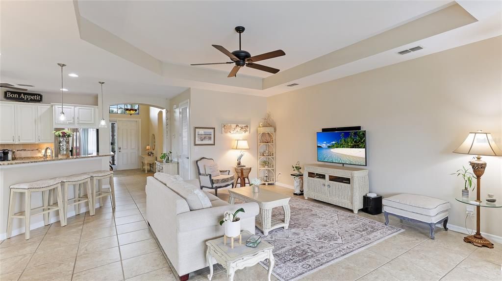 Open Concept Kitchen/Living Room Dining Room with ceiling fans, tray ceilings and abundant light from side windows and sliders out to the Lanai. Florida living!